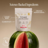 Arrae Tone Creatine Gummies displayed with fitness accessories