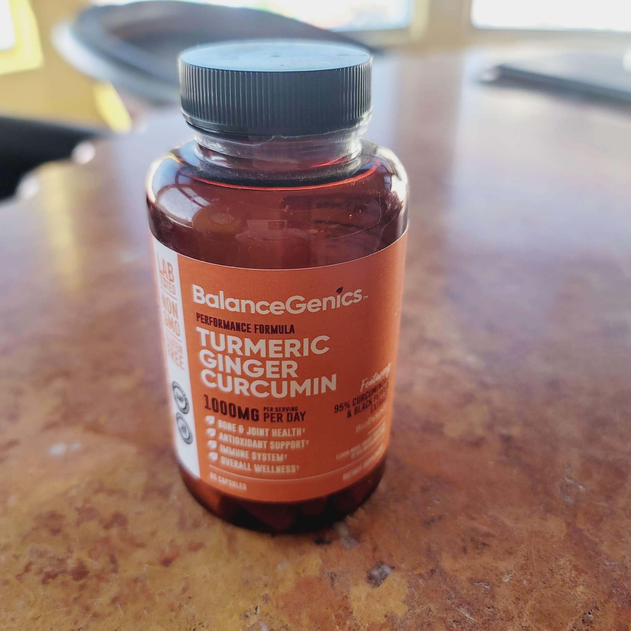 BalanceGenics Turmeric Ginger Curcumin 1000mg capsules with a measuring spoon