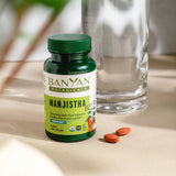 Banyan Botanicals Manjistha Herbal Supplement with a green plant background
