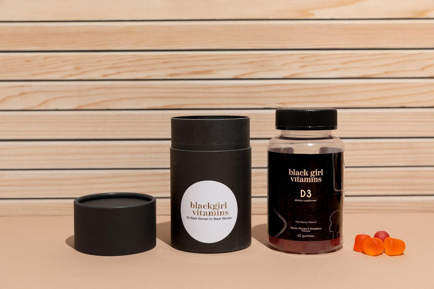 Black Girl Vitamins D3 Gummies on a wooden table with fresh fruits