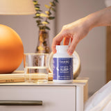 BrainMD Put Me to Sleep Naturally product with a glass of water