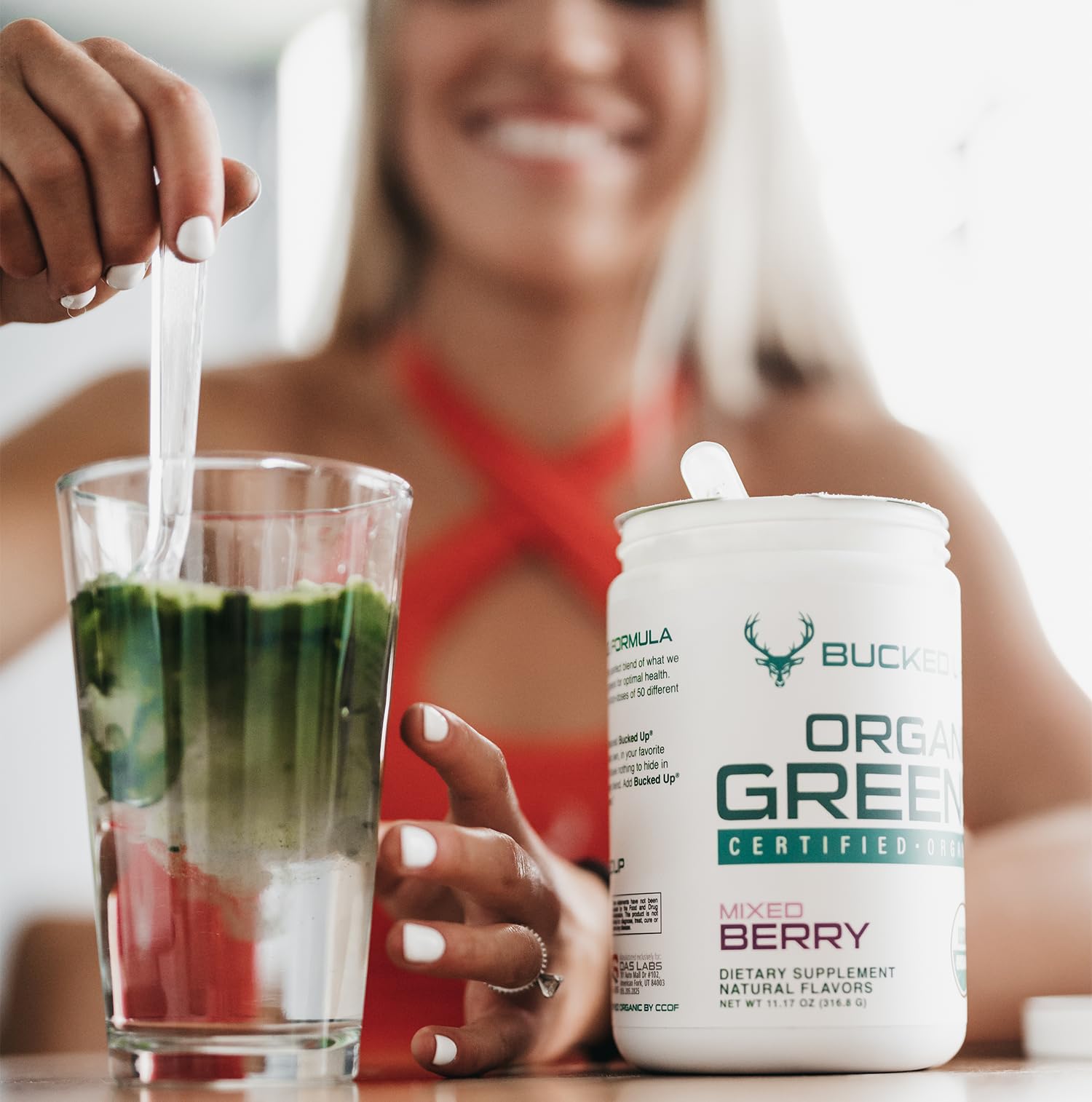 Bucked Up Organic Greens Superfood Powder 399g mixed in a glass