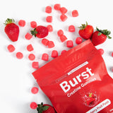 Burst Creatine Strawberry Gummies on a wooden table