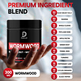 Close-up of DEDICAD Wormwood Supplement capsules on a wooden surface