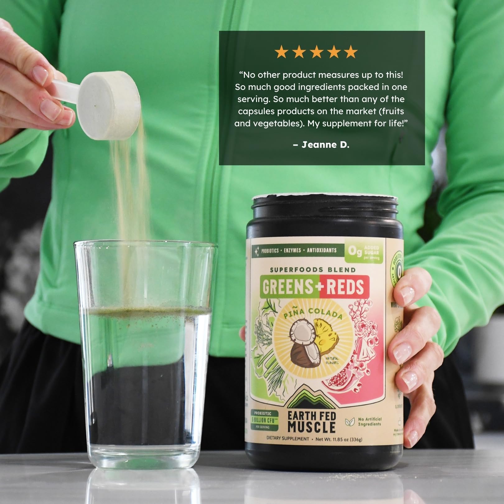 Earth Fed Muscle Greens + Reds Powder mixed in a glass