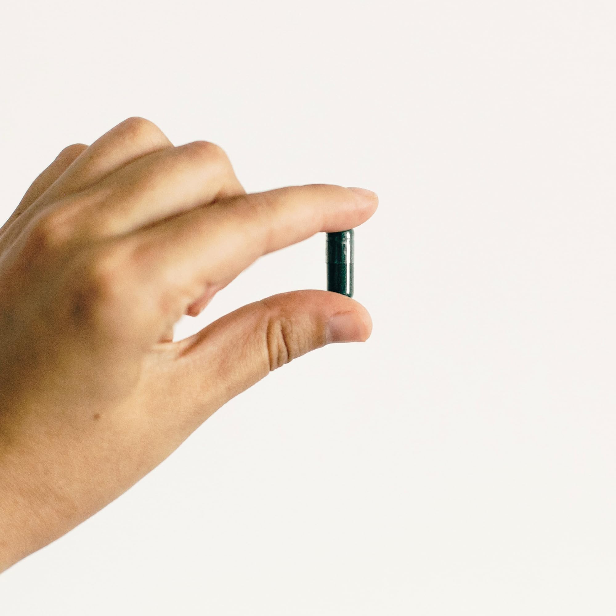 Earthborn Elements Spirulina Capsules on a wooden table