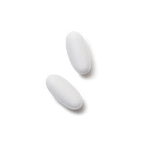 GNC Men's ArginMax capsule close-up on a wooden surface