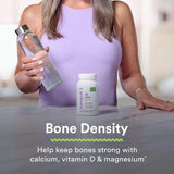 GNC Women's 50 Plus Multivitamin 120 Caplets with a glass of water