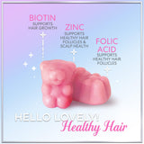 Hello Lovely! Biotin Gummies with a handful of gummies on a table