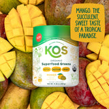 KOS Superfood Greens Powder displayed with fresh mango slices