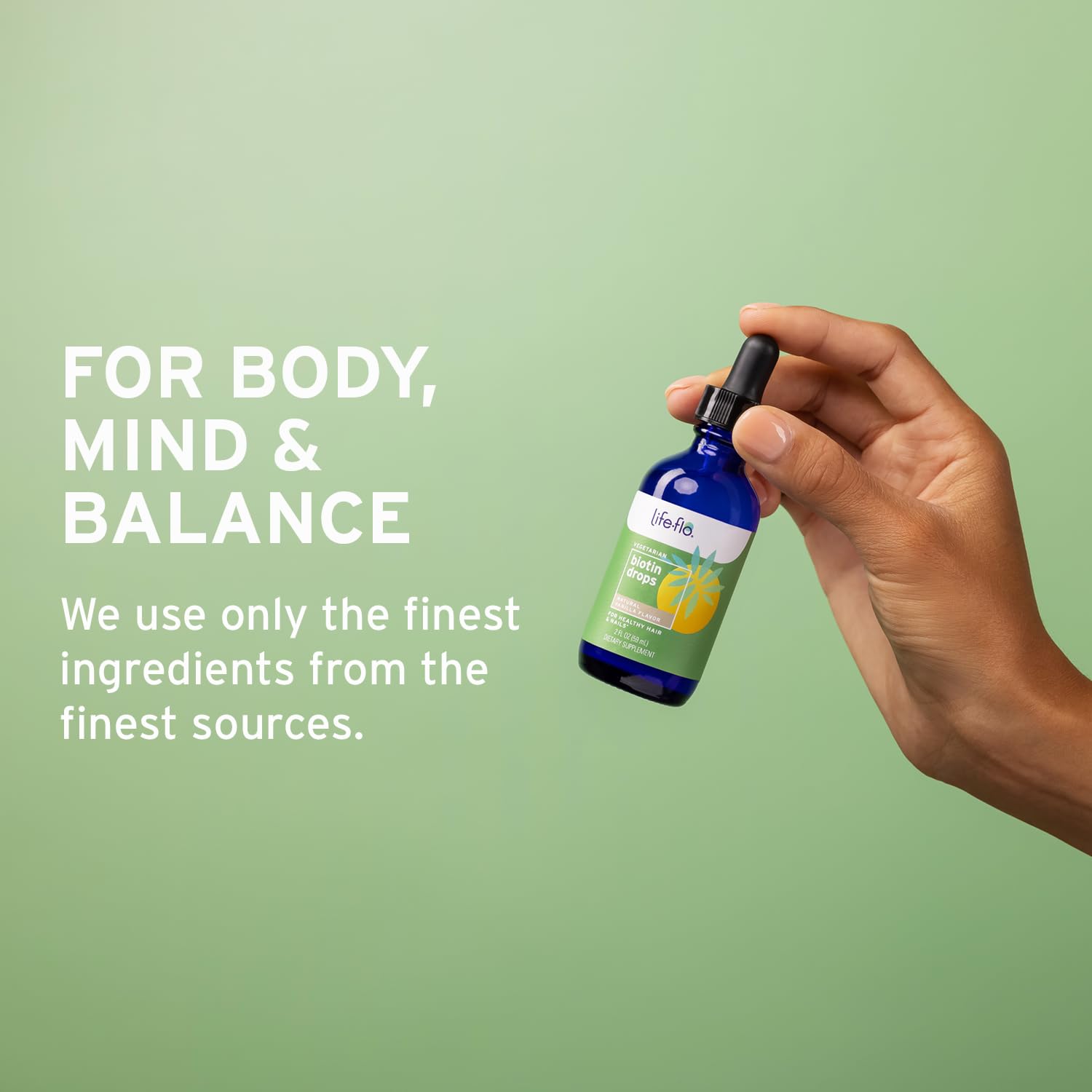 LIFE-FLO Biotin Drops on a countertop with a glass
