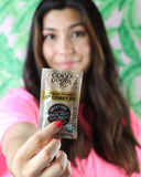 Lifestyle image of COCOGOODSCO Coconut Oil sachets on a travel bag