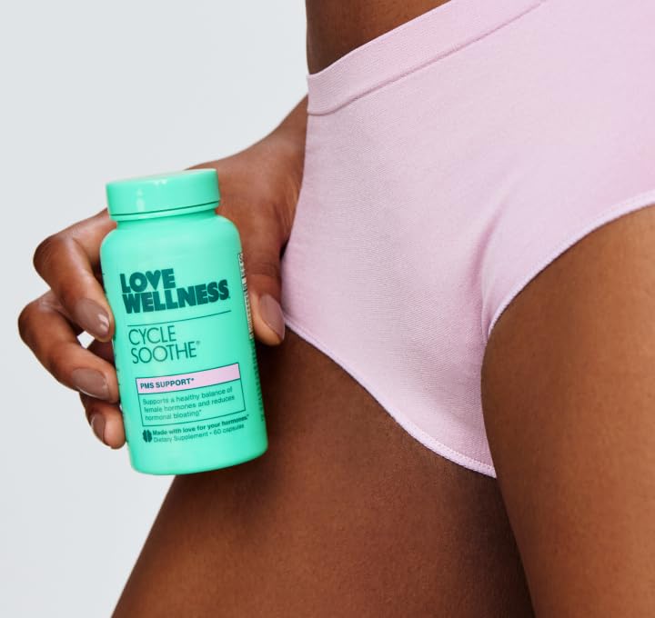 Love Wellness Cycle Soothe capsules with a glass of water