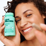 Love Wellness Daily Supplement with a measuring spoon for dosage