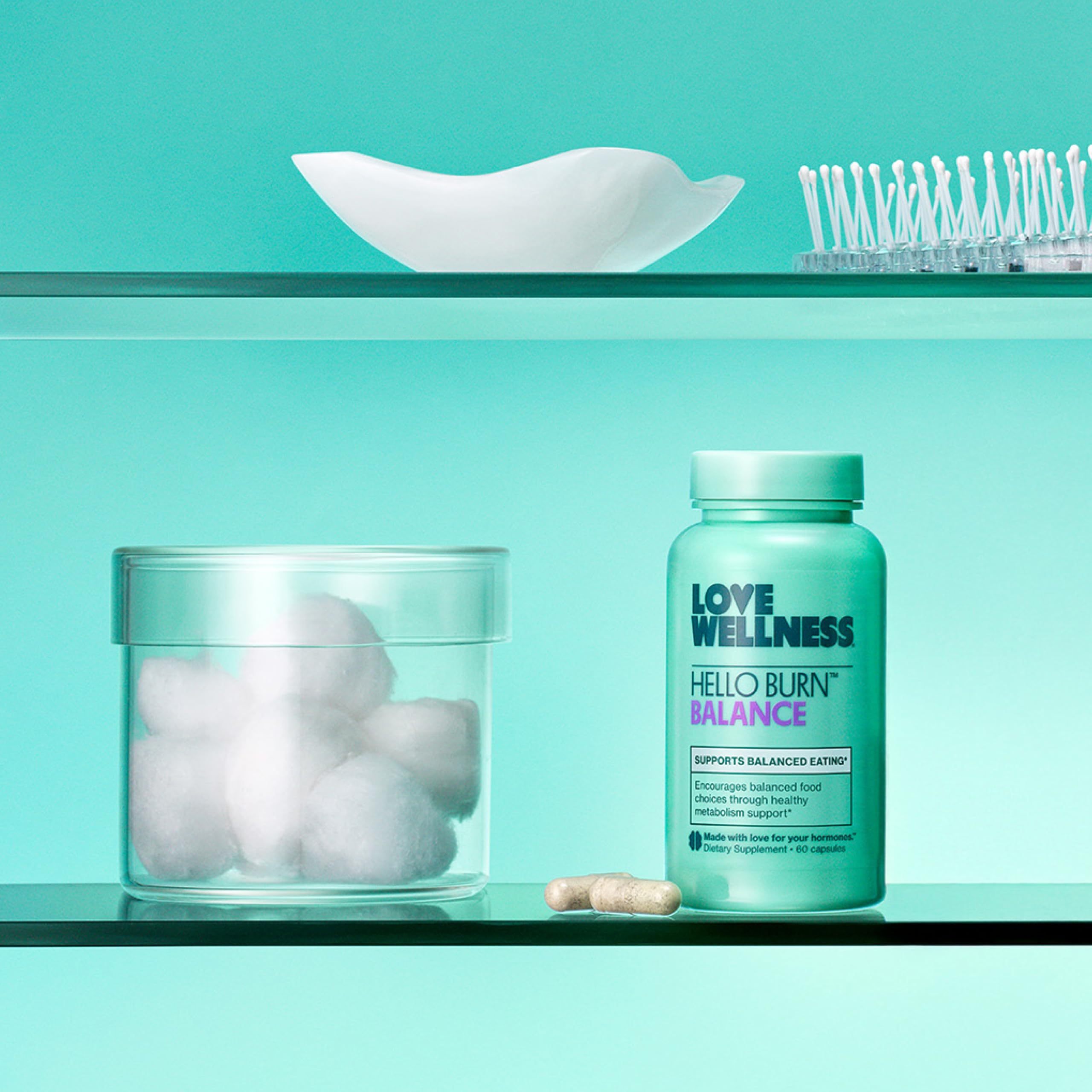 Love Wellness Hello Burn Balance capsules on a wooden table