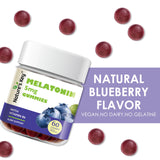 Nature's Key Melatonin Gummies on a table with a glass of water