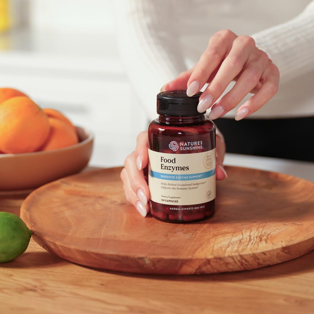 Nature's Sunshine Multi-Enzymes capsules on a wooden table
