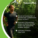 NaturesPlus Gugulipid Herbal Actives 750mg Capsules on a wooden table