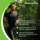 NaturesPlus Ultra Hair Plus capsules on a wooden surface