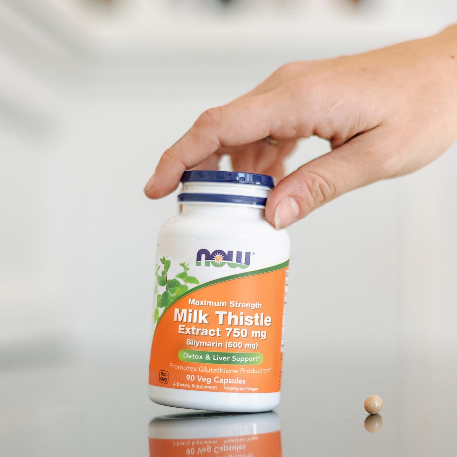NOW Foods Milk Thistle Extract 750mg capsules with a glass of water