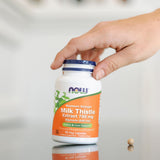 NOW Foods Milk Thistle Extract 750mg capsules with a glass of water