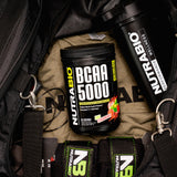 NutraBio BCAA 5000 444g product with fitness background