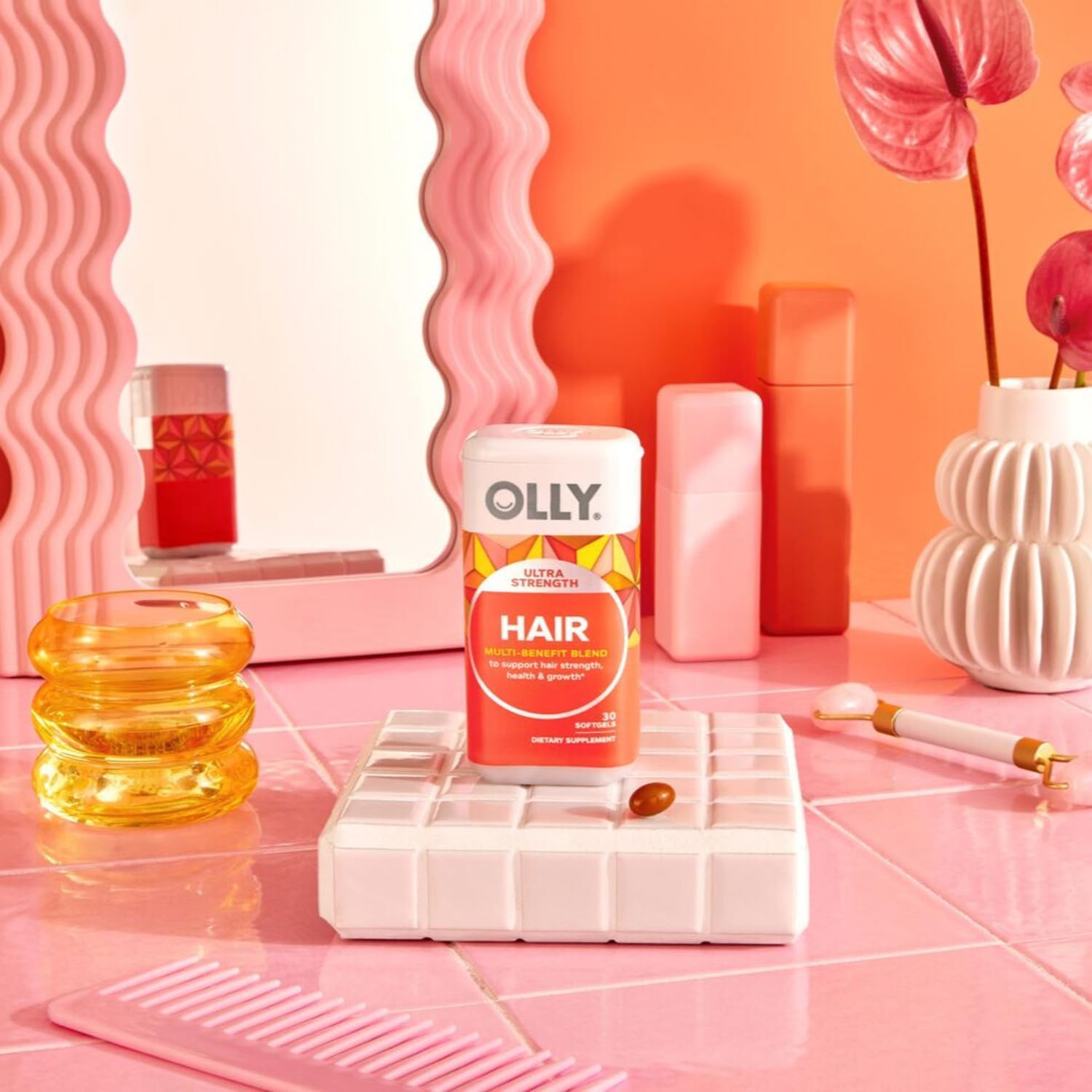 OLLY Ultra Strength Hair Softgels displayed with a glass of water