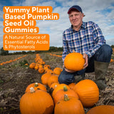 Power Grain Pumpkin Seed Oil Gummies on a wooden table with fresh oranges