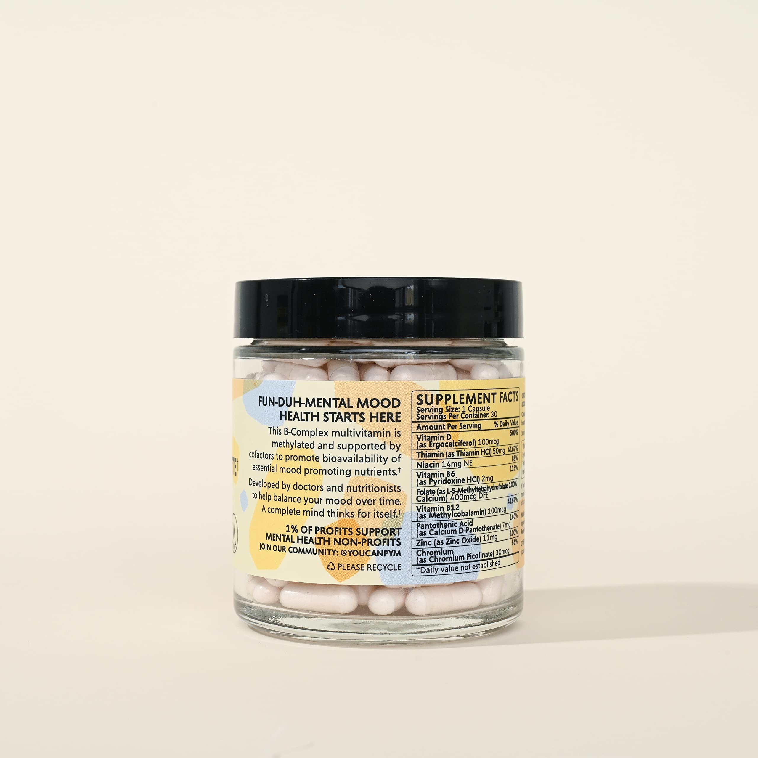 PYM Health Mood B Complete B12 supplement capsules with a glass of water