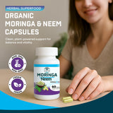 Raiz DE Moringa and Neem capsules on a wooden table