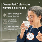 RHEASILVIA Colostrum Capsules with a glass of water