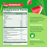 Scoop of Amazing Grass Green Superfood Powder beside a glass of mixed drink