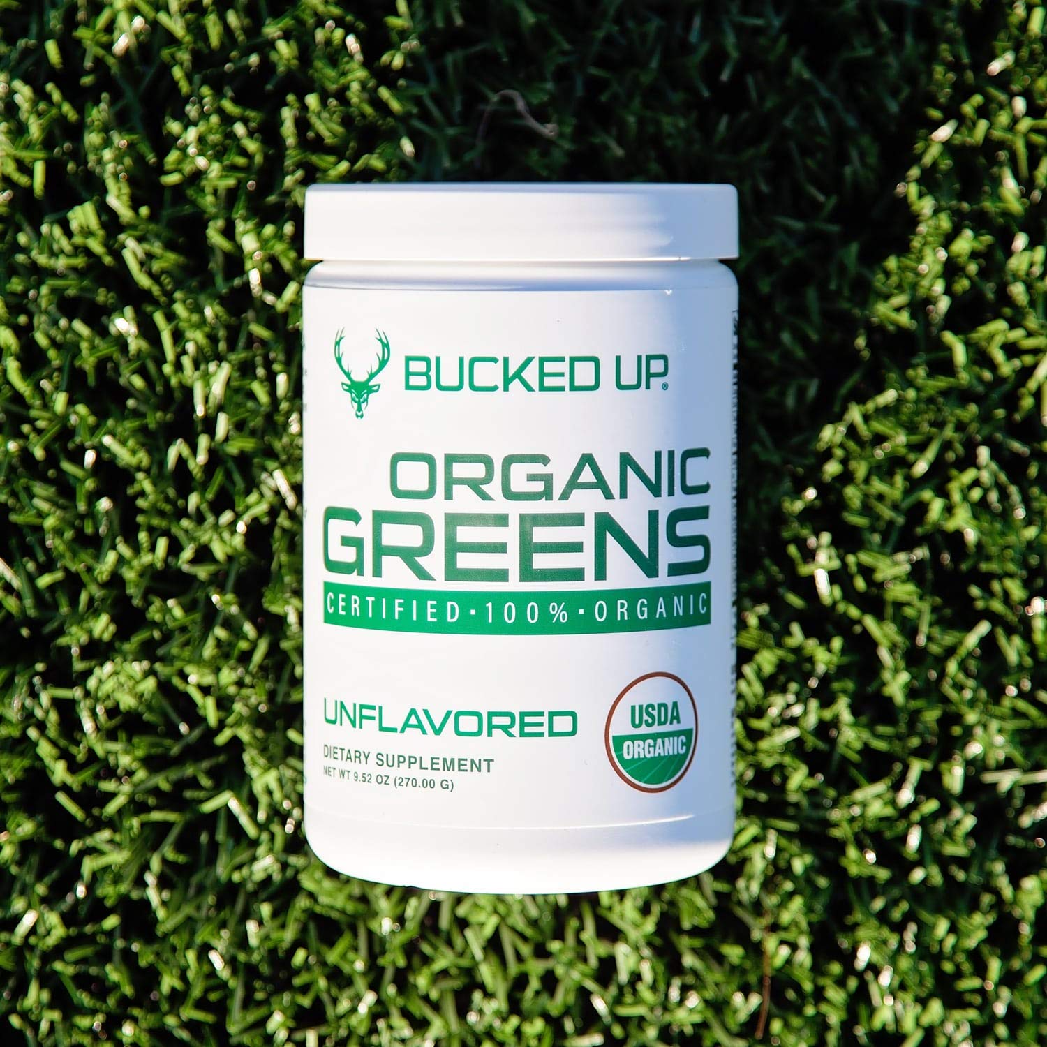 Scoop of Bucked Up Organic Greens powder on a wooden table