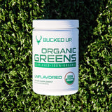 Scoop of Bucked Up Organic Greens powder on a wooden table