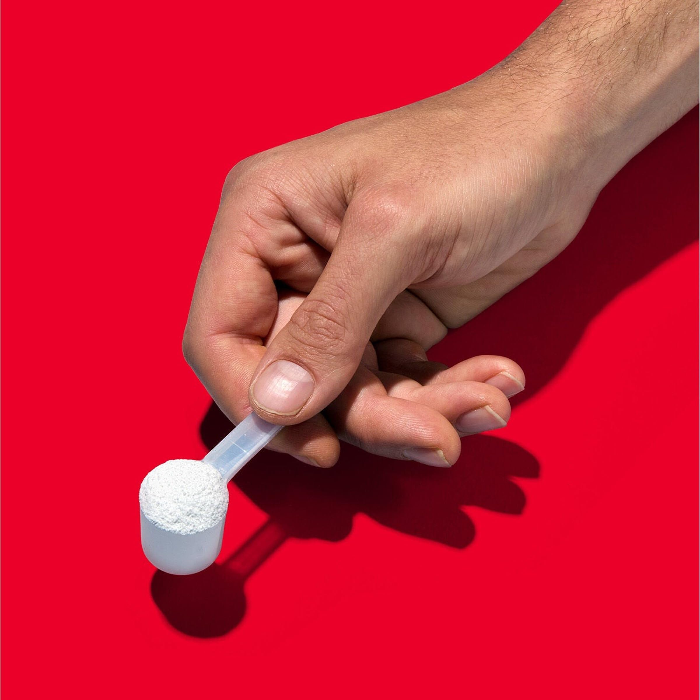 Scoop of GNC Pro Performance Creatine Monohydrate powder on a table