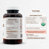 Secrets of the Tribe Thyme Capsules with a wooden spoon and thyme leaves