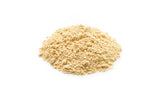 Spoonful of Yupik Organic Yellow Maca Powder on a wooden table