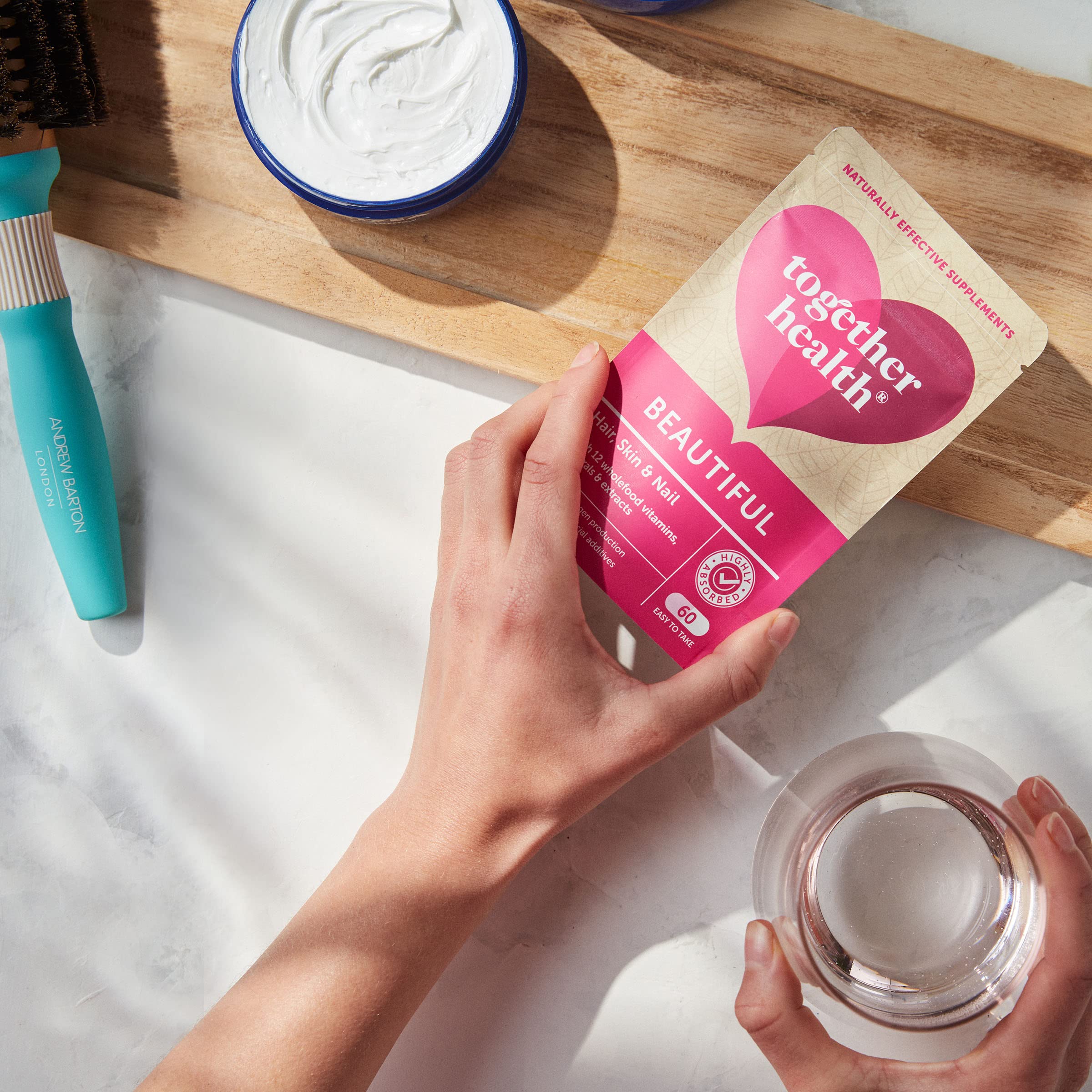 Together Hair Skin & Nail Capsules with a glass of water