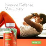 Viteey Vitamin C Gummies on a wooden table with a glass of water