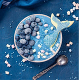 Yogurt topped with blue spirulina and berries